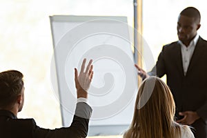 Close up rear back view young businessman raising hand.