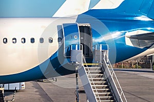 Close-up of rear door open and a passenger airstairs of a jet airplane at the airport