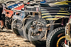 Close up of the rear side of rally raid cars with exhaust pipes, large off-road tyres and suspension. Morocco Desert Challenge