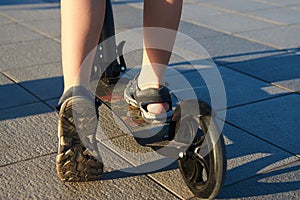 Close-up rear view of child riding kick scooter