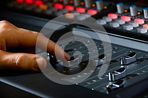 Close Up Of Recording Engineer Pushing Fader In Studio photo