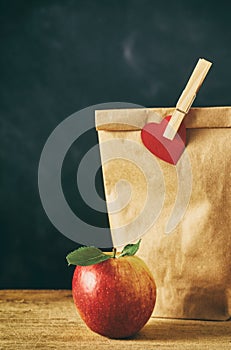 Close up on red apple and brown bag lunch