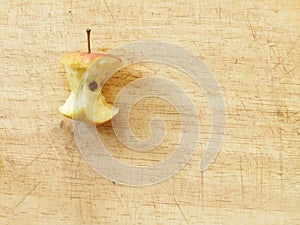 Close up red apple core on a wooden board from above