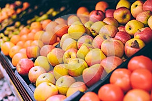 Close-up, red apples on the counters. Against the background of oranges and tangerines in the supermarket