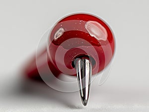 A close up of a red bottle stopper on a white surface