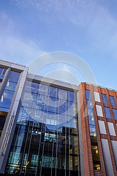 Close up of red brick new modern building facade in Tallinn near port with many glass windows. Estonia, Europe. Blue sky