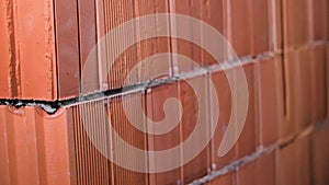 Close-up of red brick wall. Stock footage. Red brick wall of ceramic blocks was taken recently. New fresh wall built of