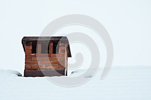 Close up on red bricked chimney on snowy rooftop