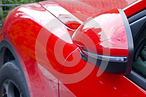 Close up of red car wing mirror.