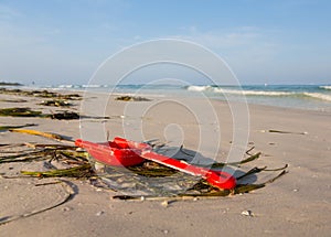 Close up of red childs spade on sandy beach