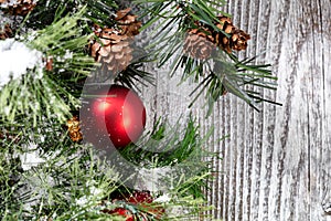 Close up of a red Christmas ball ornament on white rustic wood