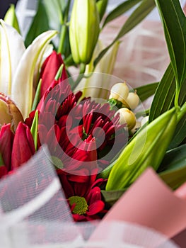 Close up of red chrysanthemums in a festive bouquet among white lilies.