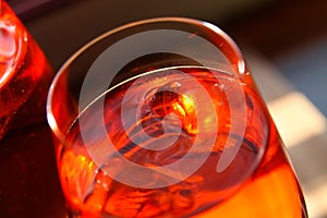 Close up of red cocktail with ice cubes in wine glass