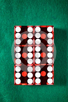 Close-up of a red dices on a green mat