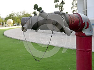 Close-up red fire hydrant spigot for connecting the fire hose in the lawn