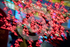 Close-up of red garland, decorative glowing neon sakura. Abstract defocused motion blurred background. Selective focus