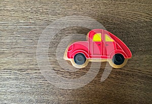 Close-up of red gingerbread car lying on the wooden table background