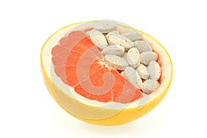 Close up of red grapefruit and pills isolated