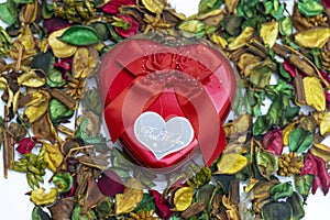 close up of A red heart metal gift box on colorful dried flowers used as wallpaper