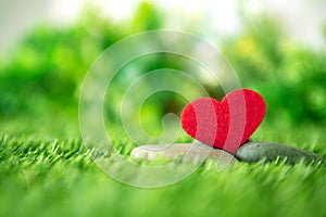 Close up red heart shape on green fresh grass , good relax and love romance feeling symbol , valentines day background