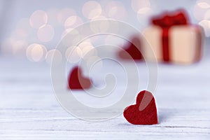 Close up of red hearts on wooden table against defocused lights. St. Valentine`s Day background.