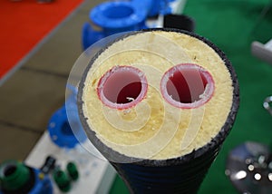 A close-up of red hot water plastic pipes, PEX tubing, insulated in one pipe. Pre-insulated pipes with double lines for an energy