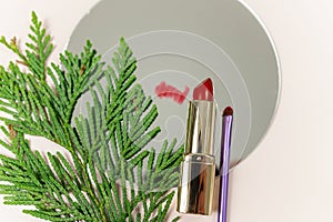 close up red lipstick and make up brush on the mirror on the beige background. make up mockup.