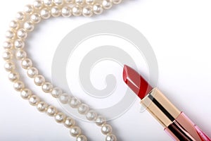 Close up on red lipstick and pearl necklace isolated on white background with copy space for your text