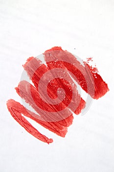 Close-up of a red lipstick smear on a white background