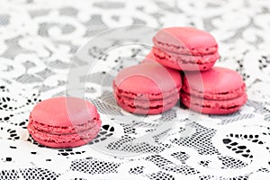 Close up of red macarons on the white  lace