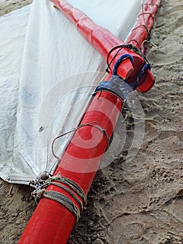 Close up of red mast and white cloth sail of traditional Caribbean boat on sand. Traditional nautical equipment, Gommier of the