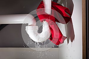 Red Napkin Tied Under The Leakage Sink Pipe photo