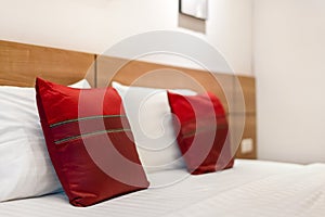 Close up of red pillow on bed decoration interior of hotel bedrooms, selective focus