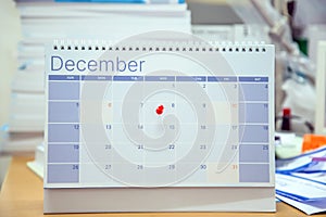 Close-up red pin on blank desk calendar and office equipment concept of event planner or personal organization for