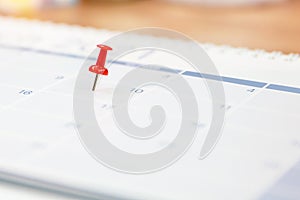 Close-up red pin on blank desk calendar and office equipment concept of event planner or personal organization for