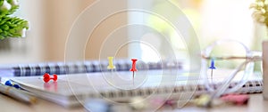 Close-up red pin on blank desk calendar with office equipment concept of event planner or personal organization for