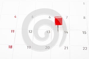 Close up red pin on White Calendar.