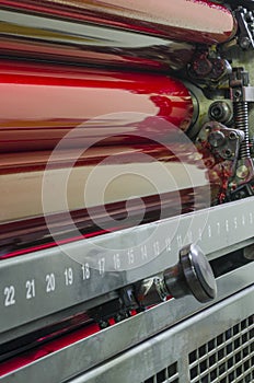 Close up of red rollers on print press machine