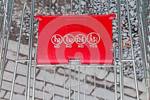 Close up of red shopping cart outside supermarket