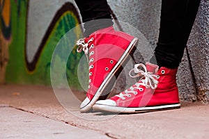 Close up of red sneakers worn by a teenager.