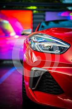 Close-up of a red sports car is parked in a multi-level parking garage