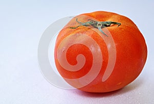 Close up of red tomato against white background