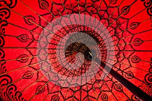 Close up of a red traditional burmese umbrella view from inside, asian background