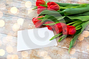 Close up of red tulips and blank paper or letter