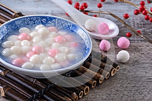 Close up of red and white tangyuan in blue bowl on wooden background for Winter solstice photo