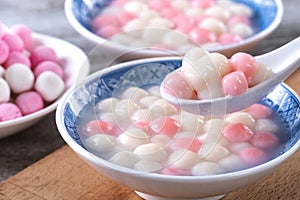 Close up of red and white tangyuan in blue bowl on wooden background for Winter solstice photo