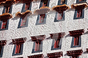 CLOSE UP: Red windows of Potala Palace overlook the scenic Tibetan landscape.