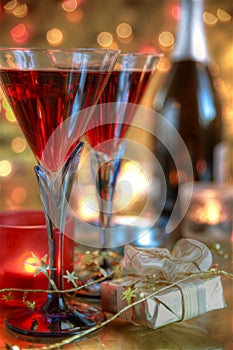 Close-up of red wine in glasses,candle and gift.