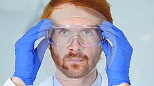 Close Up of Redhead Reseach Scientist, Doctor Wearing Protective Glasses