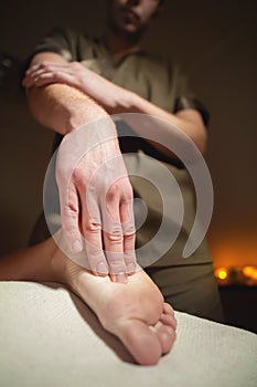 Close-up reflexology foot massage. Male masseur makes foot massage to a female client. Foot Care Concept